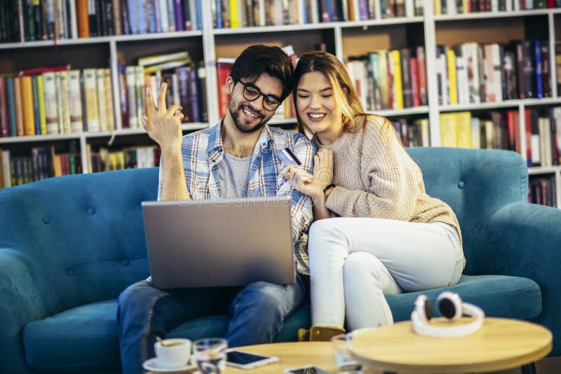 Kleines Ehepaar mit Laptop im Café mit Kreditkarte lizenzfreie stockfotografie