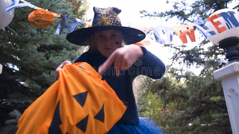 Kleines Hexenkinderfordernde Bonbons, Trick-oder-behandelnde Kinder, Halloween-Ereignis stockfotografie Kleines Hexenkinderfordernde Bonbons, Trick-oder-behandelnde Kinder, Halloween-Ereignis stockfotografie