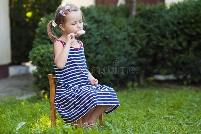 Kleines hübsches Mädchen am Sommertag eine Eiscreme essend lizenzfreie stockfotografie Kleines hübsches Mädchen am Sommertag eine Eiscreme essend lizenzfreie stockfotografie