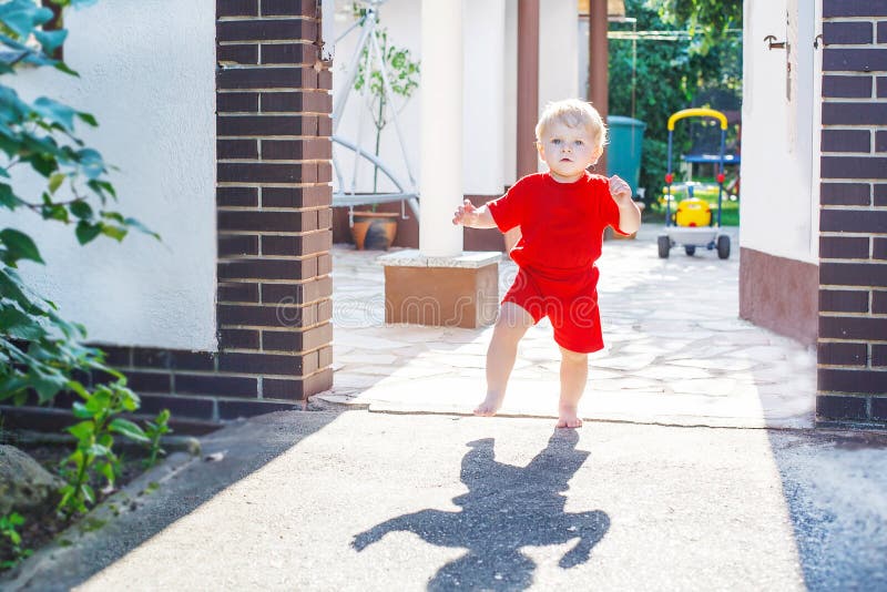 Kleines Kleinkindbaby, das draußen seine ersten Schritte macht stockfoto Kleines Kleinkindbaby, das draußen seine ersten Schritte macht stockfoto