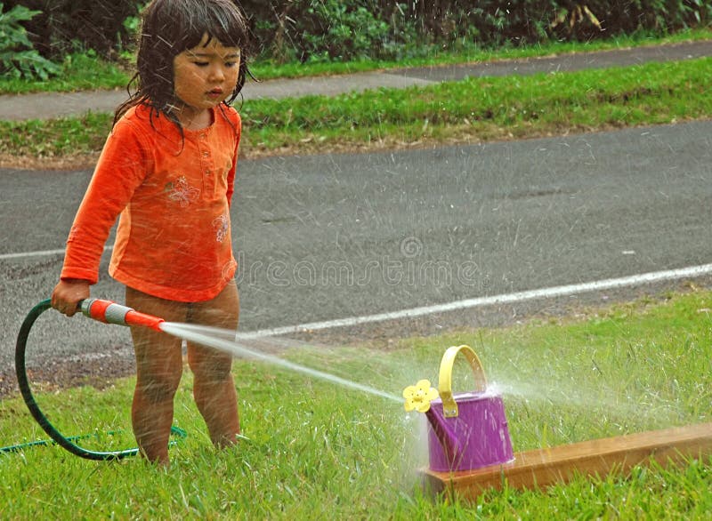 Kleines Mädchen, das mit Wasser spielt. 