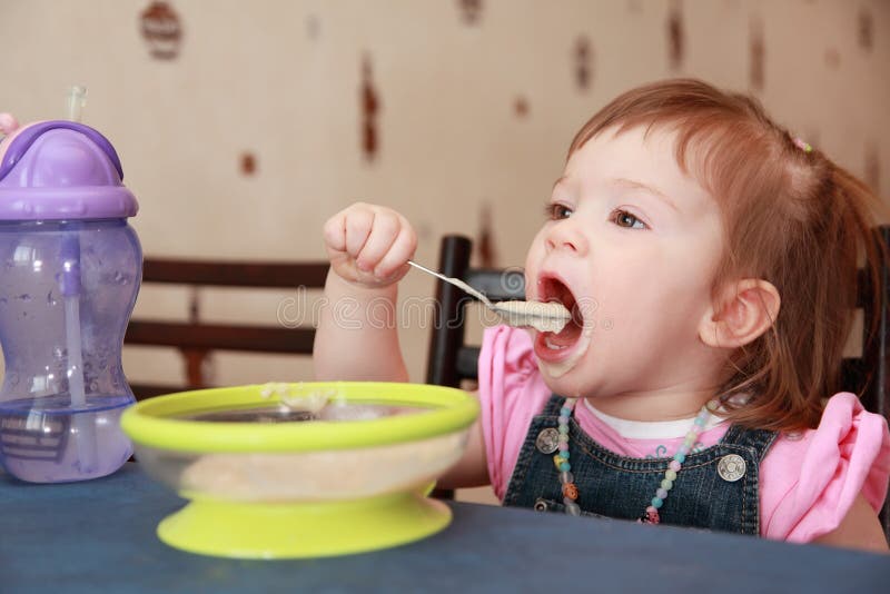 Kleines Mädchen, das Brei isst stockfoto