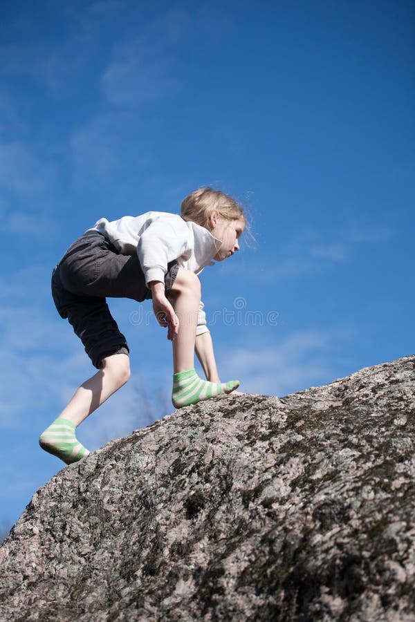 Kleines Mädchen, das den Felsen klettert lizenzfreie stockfotos Kleines Mädchen, das den Felsen klettert lizenzfreie stockfotos