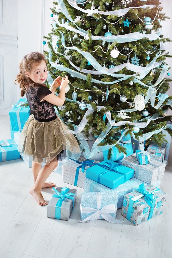 Kleines Mädchen, das einen Weihnachtsbaum verziert lizenzfreies stockfoto Kleines Mädchen, das einen Weihnachtsbaum verziert lizenzfreies stockfoto