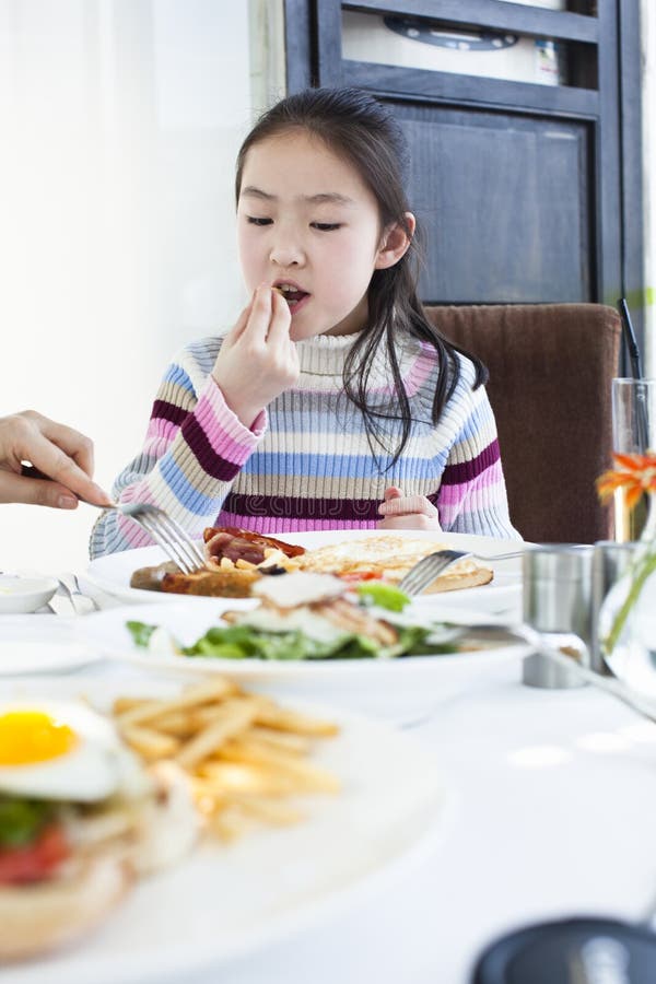 Kleines Mädchen, das großes frühstückt stockfoto Kleines Mädchen, das großes frühstückt stockfoto