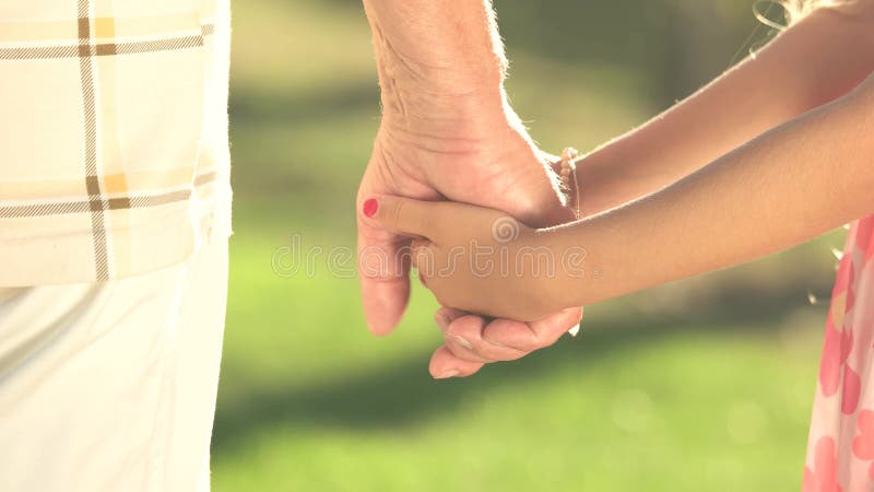 Kleines Mädchen, das Hand des Großvaters hält