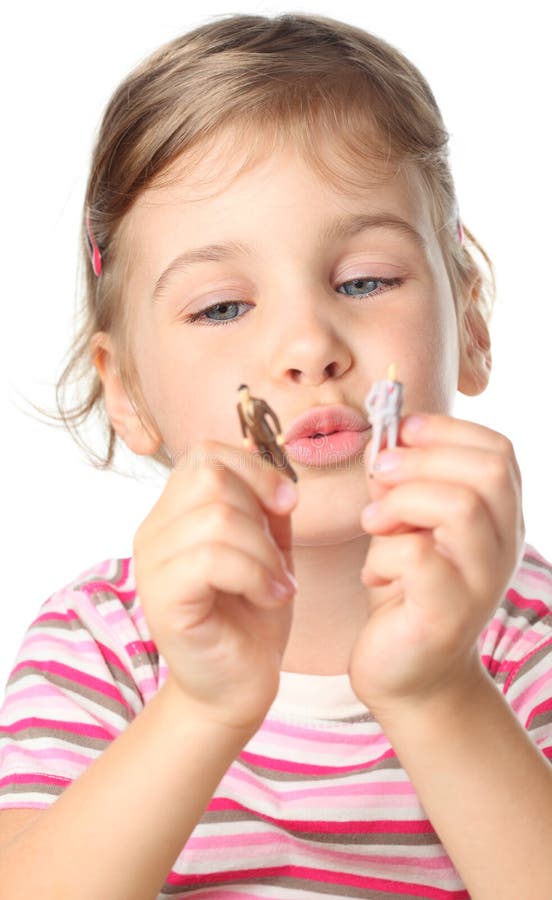 Kleines Mädchen, das kleine Spielzeugabbildungen der Leute anhält stockfotografie Kleines Mädchen, das kleine Spielzeugabbildungen der Leute anhält stockfotografie