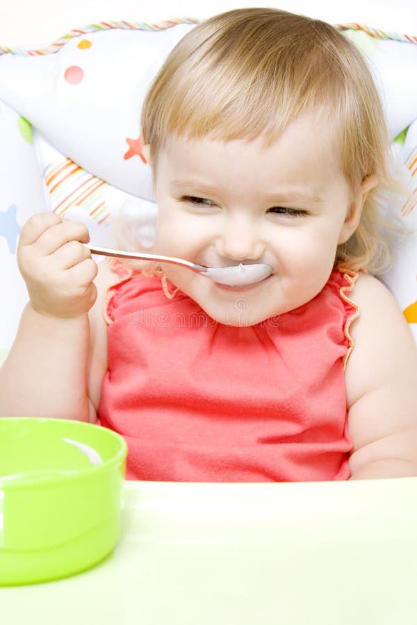 Kleines Mädchen, das mit Löffel isst stockfotos Kleines Mädchen, das mit Löffel isst stockfotos