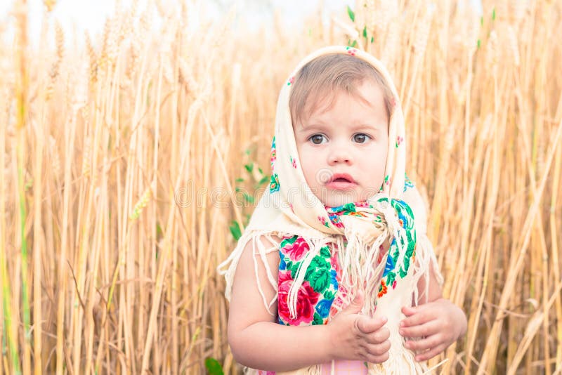 Little girl in national scarf stands in the middle of the field. Little girl in national scarf stands in the middle of the field.