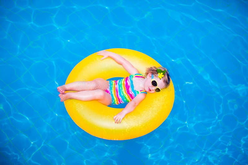 Kleines Mädchen im Swimmingpool auf aufblasbarem Ring stockfotografie Kleines Mädchen im Swimmingpool auf aufblasbarem Ring stockfotografie