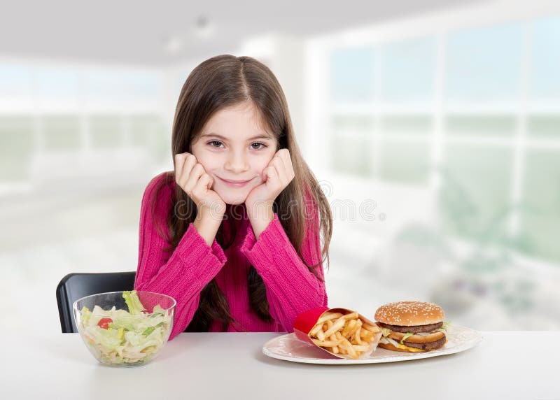 Kleines Mädchen mit gesunder und ungesunder Nahrung lizenzfreies stockfoto