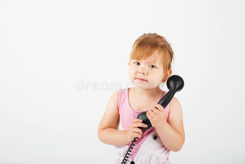 Kleines Mädchen mit Retro- Telefon gegen ein Weiß. Kleines Mädchen mit Retro- Telefon gegen einen weißen Hintergrund