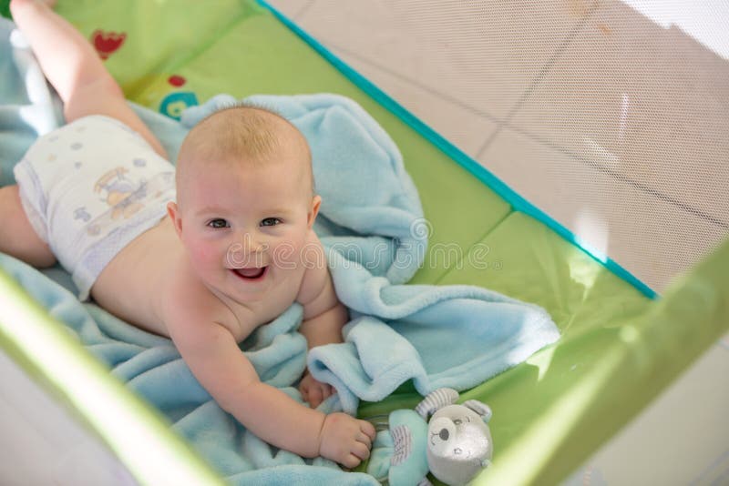 Kleines nettes Baby, spielend mit Spielwaren in einer mobilen Krippe auf einer SU stockfotos Kleines nettes Baby, spielend mit Spielwaren in einer mobilen Krippe auf einer SU stockfotos