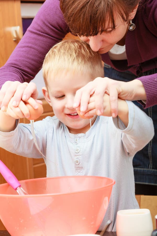 Kleinkind- und Mutterkochen, Kuchen in der Schüssel machend stockfotografie Kleinkind- und Mutterkochen, Kuchen in der Schüssel machend stockfotografie