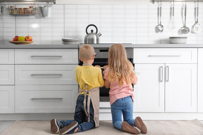 Kleinkinder, die etwas im Ofen backen lizenzfreie stockfotos Kleinkinder, die etwas im Ofen backen lizenzfreie stockfotos