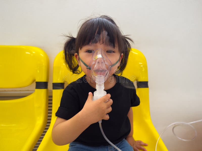 Kleinkindermädchen mit Dampfinhalator und Inhalationsmaske für die Verneblase im Krankenhaus stockfotos