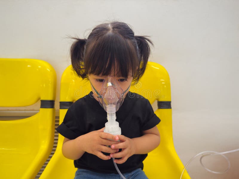 Kleinkindermädchen mit Dampfinhalator und Inhalationsmaske für die Verneblase im Krankenhaus
