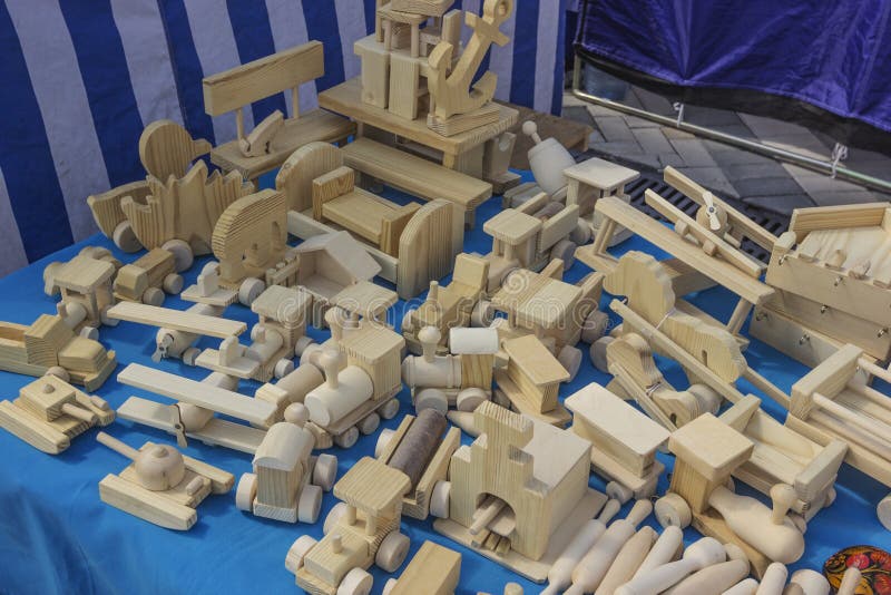 Hübsche handgefertigte Spielzeuge aus Holz für Kinder auf einem blauen Tuch stockfotos