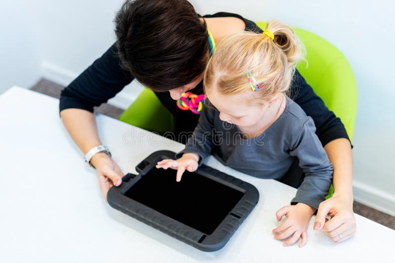 Kleinkindmädchen in der Kinderberuflichen Therapie-Sitzung, die sensorische spielerische Übungen mit ihrem Therapeuten verwendet stockfotografie Kleinkindmädchen in der Kinderberuflichen Therapie-Sitzung, die sensorische spielerische Übungen mit ihrem Therapeuten verwendet stockfotografie