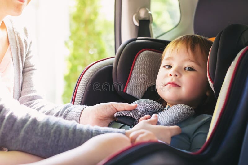 Kleinkindmädchen in ihrem Autositz lizenzfreies stockbild Kleinkindmädchen in ihrem Autositz lizenzfreies stockbild