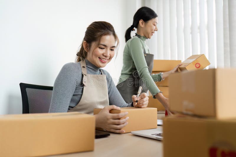 Kleinunternehmer, die Verpackungs- und Versandaufträge in einem modernen Büroumfeld bearbeiten lizenzfreie stockfotos