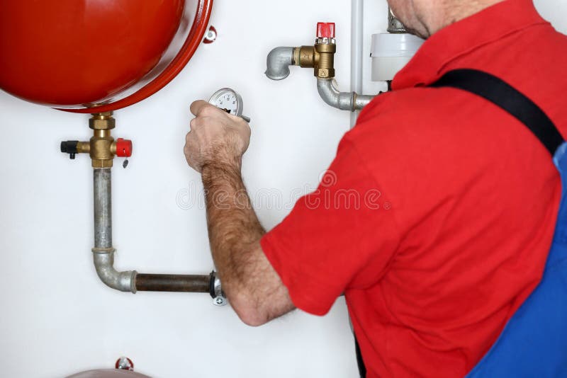 Klempner arbeitet in einem Heizungsraum stockbild Klempner arbeitet in einem Heizungsraum stockbild