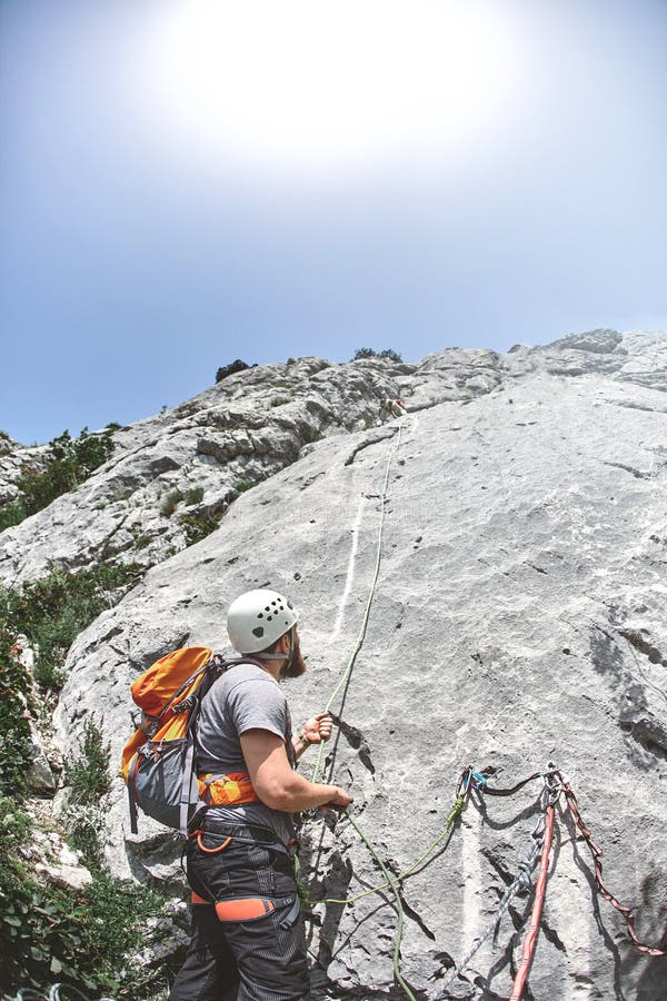 Kletterer steht auf einer Leiste auf einem Felsen und sichert den Partner lizenzfreie stockfotografie Kletterer steht auf einer Leiste auf einem Felsen und sichert den Partner lizenzfreie stockfotografie