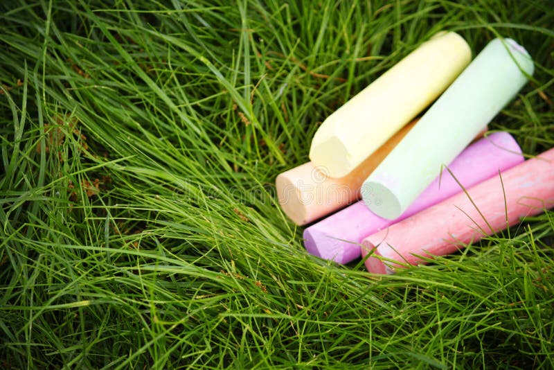 Kleurrijk krijt op een groene grasachtergrond De ruimte van het exemplaar stock afbeelding Kleurrijk krijt op een groene grasachtergrond De ruimte van het exemplaar stock afbeelding