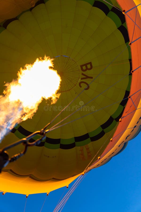 Kleurrijke gele hete luchtballon die met van binnenuit het materiaal van de de vlamhitte van de gasbrand over Cappadocia, lage ho royalty-vrije stock foto Kleurrijke gele hete luchtballon die met van binnenuit het materiaal van de de vlamhitte van de gasbrand over Cappadocia, lage ho royalty-vrije stock foto