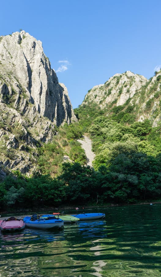 Kleurrijke Kano's in Matka-Canion, Macedonië zonder persoon Kajaks in een pijler en zonsondergang in de bergen en het meer stock fotografie Kleurrijke Kano's in Matka-Canion, Macedonië zonder persoon Kajaks in een pijler en zonsondergang in de bergen en het meer stock fotografie