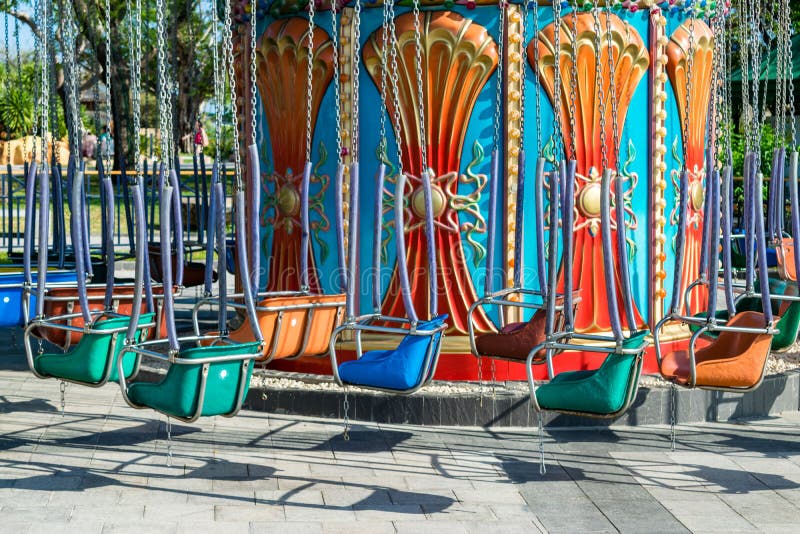 Kleurrijke metaalschommeling op kettingen in een pretpark zonder mensen stock afbeelding Kleurrijke metaalschommeling op kettingen in een pretpark zonder mensen stock afbeelding