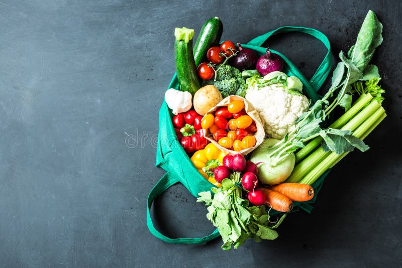 Kleurrijke organische groenten in groene eco het winkelen zak