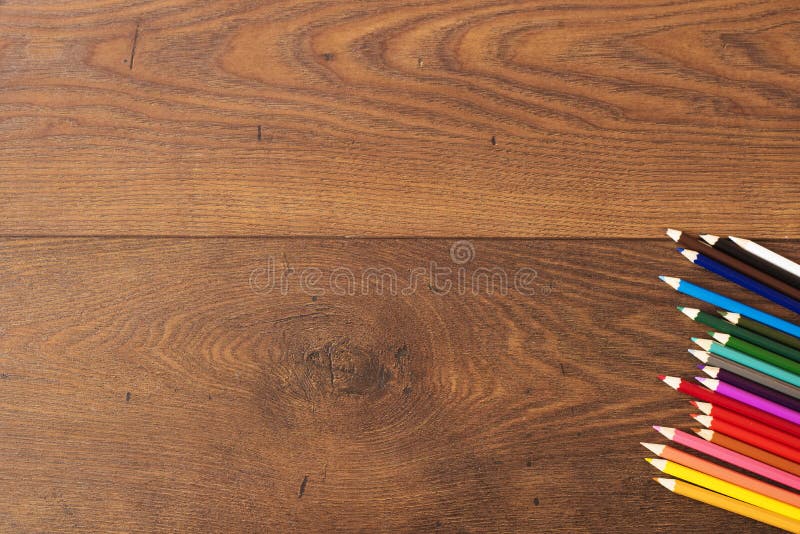 Kleurrijke potloden op de bruine houten lijstachtergrond Kader van kleurpotloden over hout met exemplaarruimte