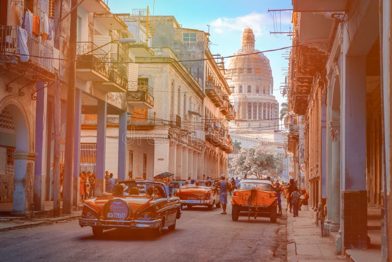 Kleurrijke straat in Oud Havana met oude auto's en het Capitoolgebouw royalty-vrije stock foto Kleurrijke straat in Oud Havana met oude auto's en het Capitoolgebouw royalty-vrije stock foto
