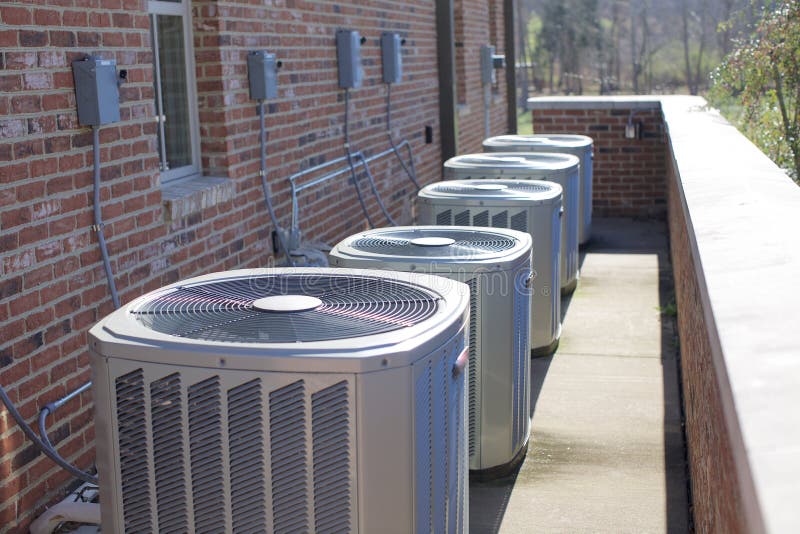 Multiple air conditioning heating and cooling units installed outside a building. Multiple air conditioning heating and cooling units installed outside a building.