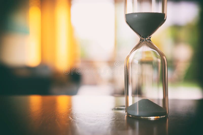 Klocka för årgångsglas över bord arkivfoton