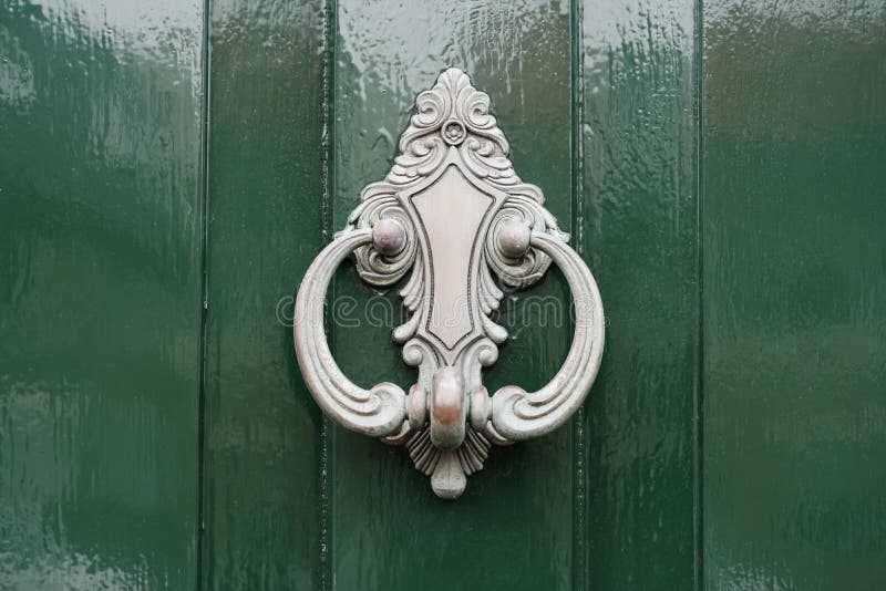 Klopper in zilver op groene geschilderde houten deur stock fotografie Klopper in zilver op groene geschilderde houten deur stock fotografie