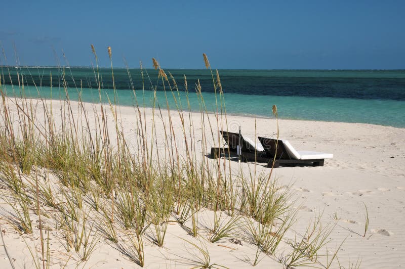 Klubsessel auf dem Strand in den Türken u. in Caicos lizenzfreies stockbild Klubsessel auf dem Strand in den Türken u. in Caicos lizenzfreies stockbild