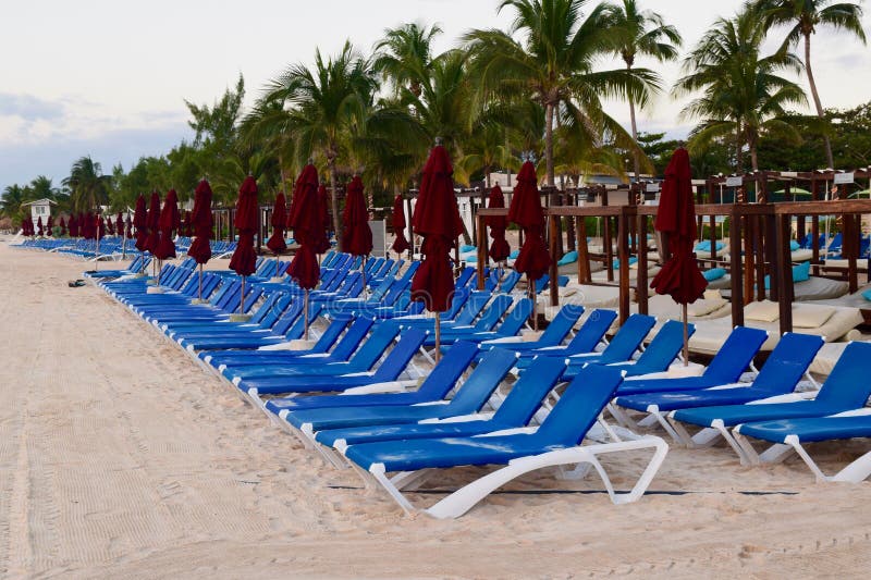 Klubsessel und Regenschirme am Strandurlaubsort lizenzfreies stockbild Klubsessel und Regenschirme am Strandurlaubsort lizenzfreies stockbild