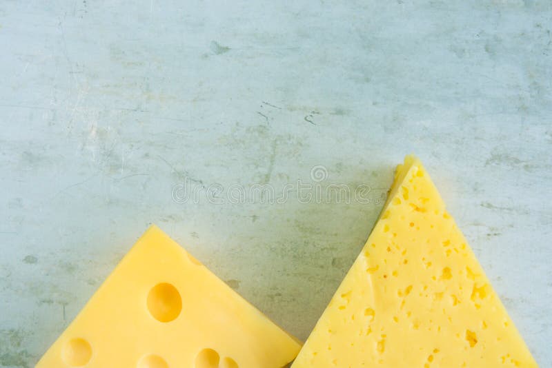 Klumpen und Keil des alpinen sahnigen appetitanregenden gelben Tilsiters und des Maasdam-Käses auf verkratztem Grey Metal Backgro stockfotos Klumpen und Keil des alpinen sahnigen appetitanregenden gelben Tilsiters und des Maasdam-Käses auf verkratztem Grey Metal Backgro stockfotos