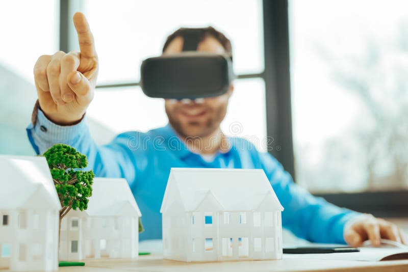 Klyftig specialist som arbetar i virtuell verklighet och pekar upp hans finger arkivbild