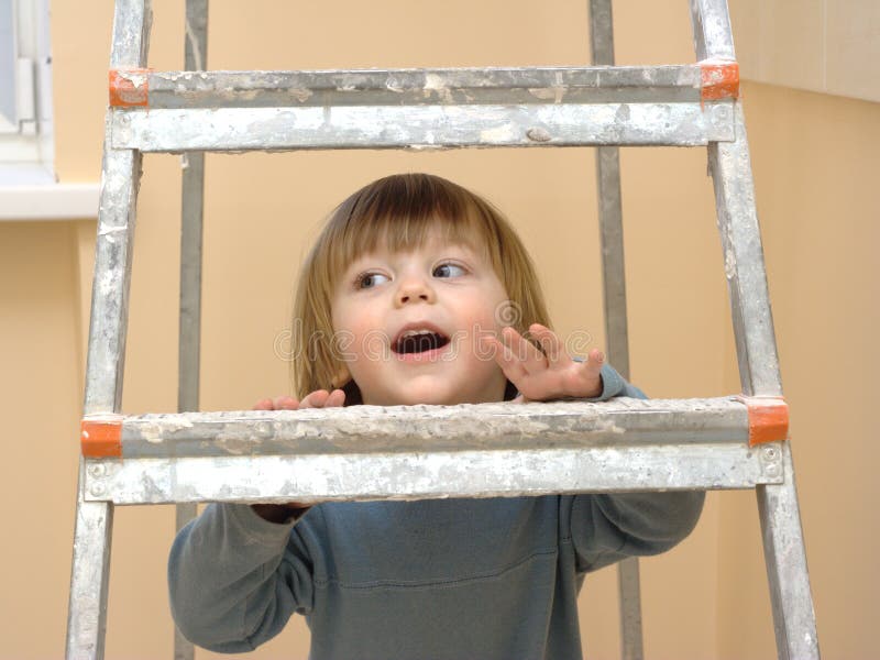 Little boy looking through the step-ladder. Little boy looking through the step-ladder