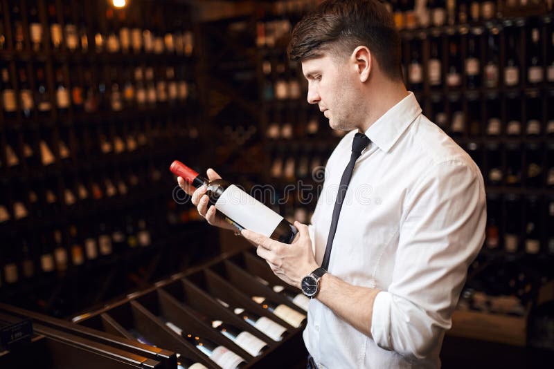 Knappe elegante mens die klanten helpen om wijn te kiezen stock foto's Knappe elegante mens die klanten helpen om wijn te kiezen stock foto's