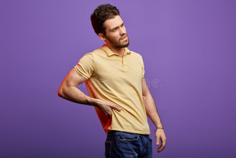 Knappe gebaarde mens die zijn rug houden royalty-vrije stock fotografie Knappe gebaarde mens die zijn rug houden royalty-vrije stock fotografie