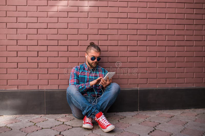 Knappe hipsterkerel die aan digitale tablet werken royalty-vrije stock foto's Knappe hipsterkerel die aan digitale tablet werken royalty-vrije stock foto's