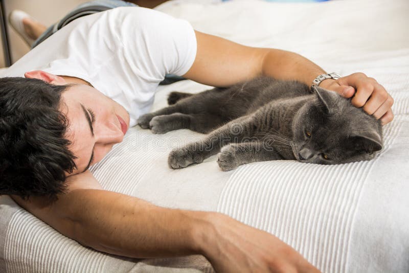 Knappe Jonge Mens die zijn Gray Cat Pet knuffelen