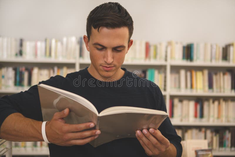 Knappe jonge mensenlezing bij de bibliotheek royalty-vrije stock afbeelding Knappe jonge mensenlezing bij de bibliotheek royalty-vrije stock afbeelding