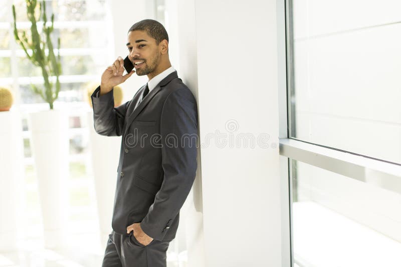 Knappe jonge zwarte mens met mobiele telefoon stock afbeelding Knappe jonge zwarte mens met mobiele telefoon stock afbeelding