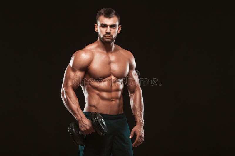 Knappe machts atletische mens in opleiding omhoog pompend spieren met domoren in een gymnastiek geïsoleerd geschiktheids spierlic royalty-vrije stock fotografie Knappe machts atletische mens in opleiding omhoog pompend spieren met domoren in een gymnastiek geïsoleerd geschiktheids spierlic royalty-vrije stock fotografie