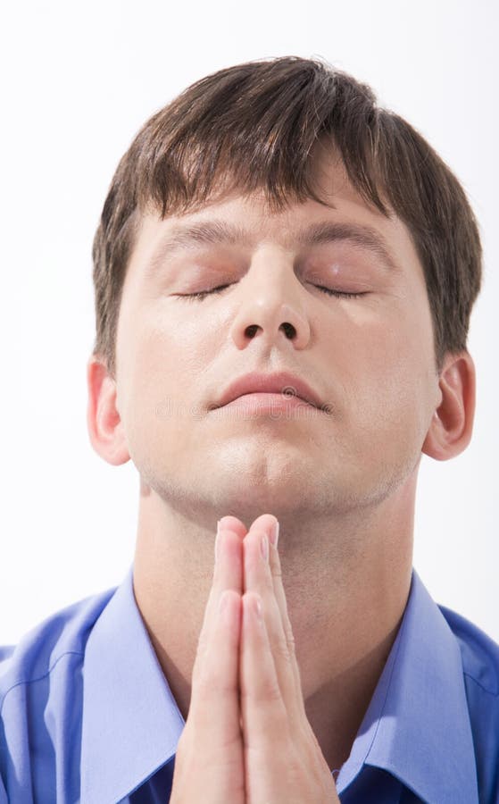 Face of young man with closed eyes and his hands keeping in touch beneath his chin. Face of young man with closed eyes and his hands keeping in touch beneath his chin